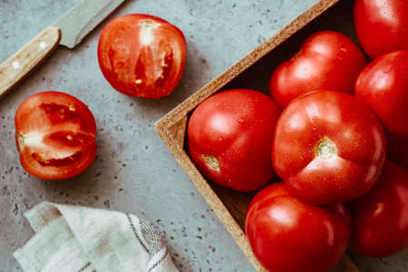 Fresh ripe red tomatoes in wooden box on a cooking tableの写真素材