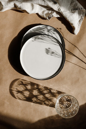 Modern minimalist ceramics plates with a linen cloth over kraft paper background. Natural products or food concept, top view, flat lay.の写真素材