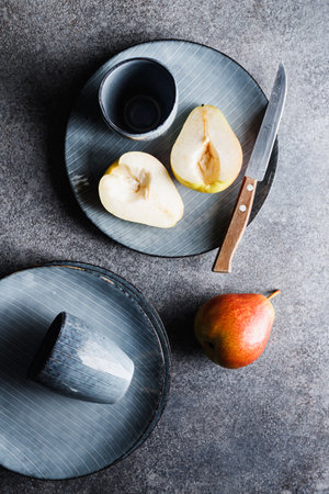 Blue food ceramic set with plates and pears over gray textured background. Minimalist style, top view.の写真素材