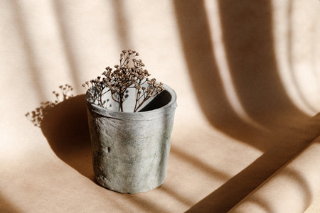 Abstract creative minimal composition with a clay pot and dry grass against kraft paper. Natural and ecological products concept.の写真素材