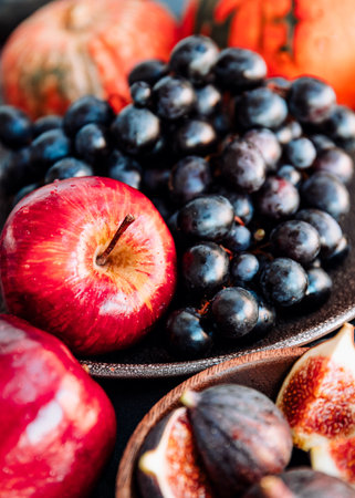 Autumn food, red apples, figs, grapes and pumpkin.の写真素材