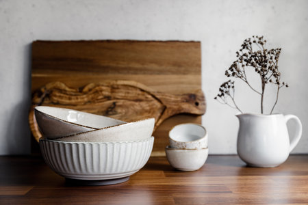 Set of kitchen ceramic tableware and wooden cutting boards on a table. Eco style home still life.の写真素材