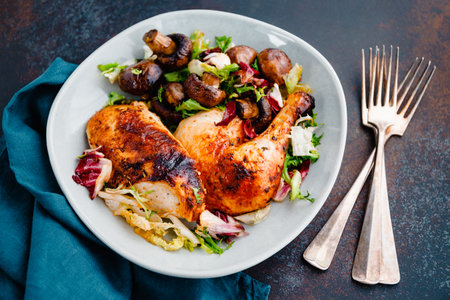 Roasted chicken leg and breast with fresh salad and champignons on a plate.