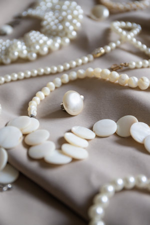 Many different pearl jewelry on a beige background.の写真素材