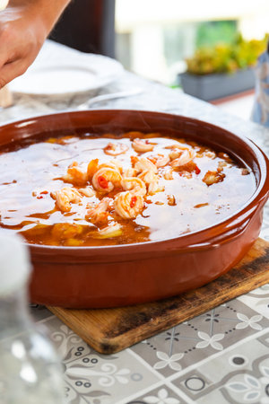 Spanish traditional food shrimp pil pil with red pepper and garlic on a family dinnerの写真素材