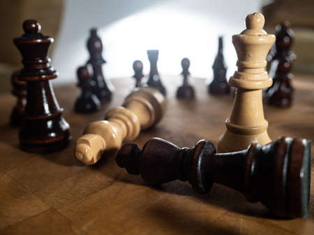 Chess pieces and kitchen knife. Strategy game. It is played on a 64 square black and white board.