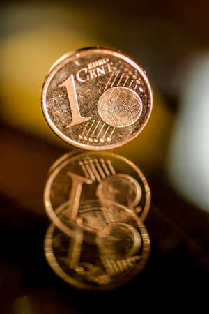 Different Euro coins balance on a glass table.の写真素材