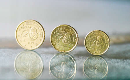 Different Euro coins balance on a glass table.の写真素材