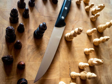 Chess pieces and kitchen knife. Strategy game. It is played on a 64 square black and white board.の写真素材