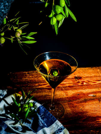 Martini glass with olive oil and olivesの写真素材