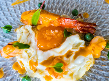 egg fried in olive oil with prawnsの写真素材