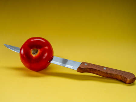 Tomato stuck with a knifeの写真素材