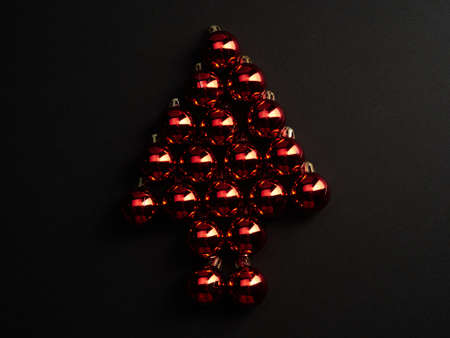 Shiny red Christmas balls placed in the shape of a fir tree