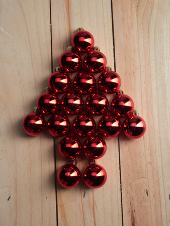 Shiny red Christmas balls placed in the shape of a fir tree