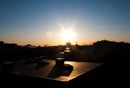 Sunset on a clear day over an industrial rooftopの写真素材