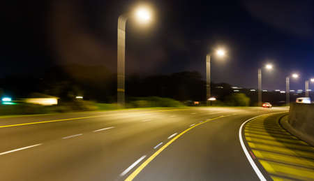 Highway speed blur at dusk with street lightsの写真素材