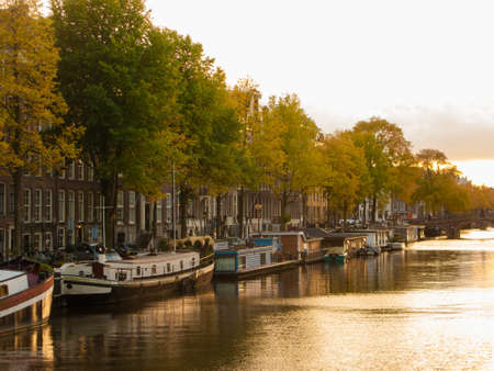Amsterdam canal and boats with golden afternoon lightの写真素材