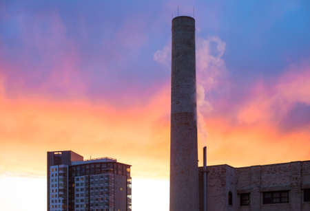 Industrial smokestack with red and blue sunsetの写真素材