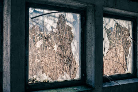 Abandoned warehouse with broken windows on a sunny day
