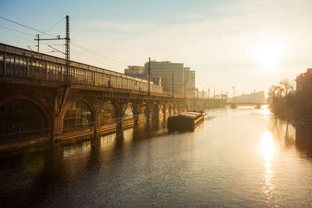 Berlin's River Spree with barge and bright sunの写真素材