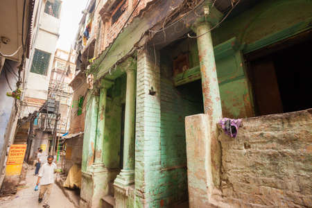 VARANASI, INDIA - 26 Oct 2016: Man walks down back alleyways on October 26, 2016 in Varanasi, Indiaのeditorial素材