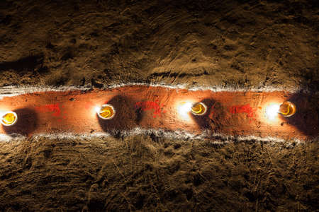 Oil lamps on a painted red pathway for Lakshmi Puja during the Diwali / Tihar holiday in Nepalの写真素材