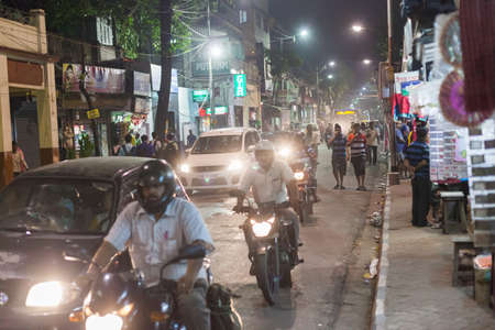 KOLKATA, INDIA - 21 Oct 2016: Motorcycles and cars crowd the street at night on October 21, 2016 in...