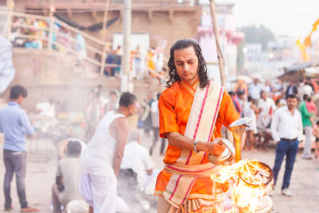 VARANASI, INDIA - 28 Oct 2016: Hindu priest performs a dawn ritual at Dashaswamedh Ghat on October 28, 2016 in Varanasi, Indiaのeditorial素材