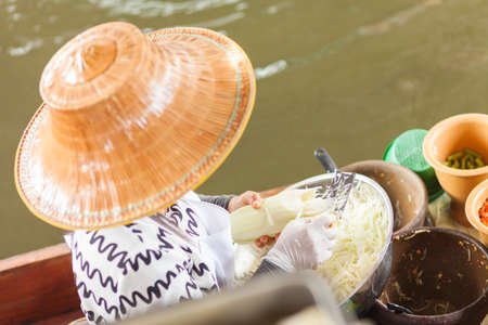 BANGKOK - 15 Oct 2016: A woman in a floating kitchen vegetables on October 15, 2016 in Taling Chan Floating Market, Bangkok, Thailand.のeditorial素材