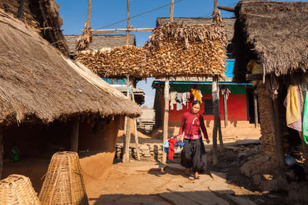 BANDIPUR, NEPAL - 23 December 2016: Woman carrying laundry through Ramkot village, 23 December 2016 near Bandipur, Nepalのeditorial素材