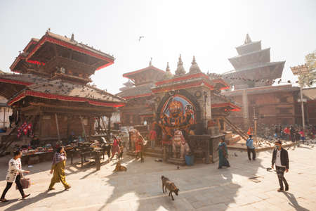KATHMANDU, NEPAL - 16 December 2016: Passerby walk past Jagannath Temple and Swet Bhairav in Durbar...