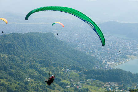 Paragliders float over Pokhara, Nepal's Fewa Lake and Lakeside tourist areaの写真素材