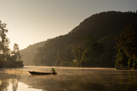 Ferryman takes passengers across Fewa lake at sunriseの写真素材