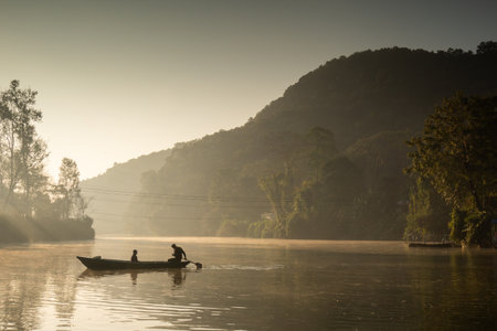 Ferryman takes passengers across Fewa lake at sunriseの写真素材