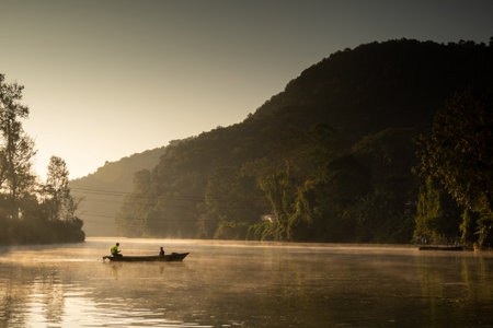Ferryman takes passengers across Fewa lake at sunriseの写真素材