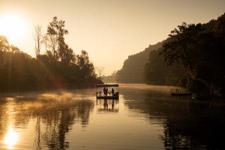 Ferryman takes passengers across Fewa lake at sunriseの写真素材