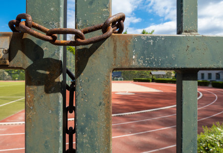 Chain on the gate of an ourdoor track, closed due to COVIDの写真素材