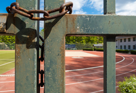 Chain on the gate of an ourdoor track, closed due to COVIDの写真素材