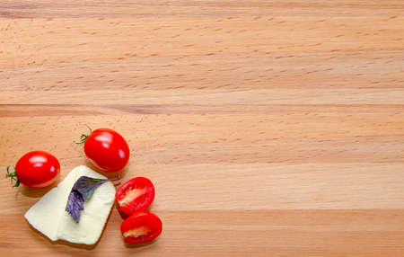 Cheese and tomato on boardの写真素材