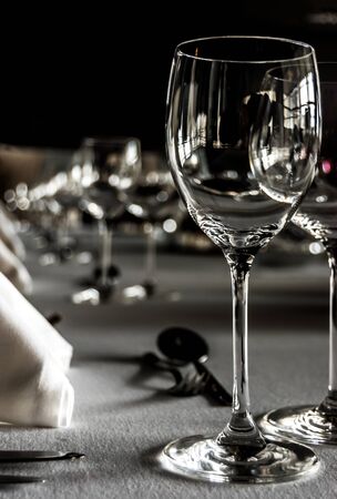Black and white shot of a table setting with wineglasses, white napkins and silwerware on white tablecloth.の写真素材