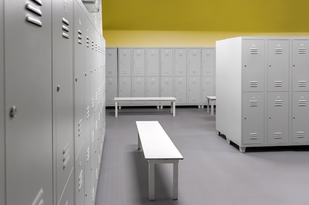 Rows of steel lockers with white benchesの写真素材