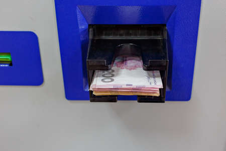 Blue ATM load money for 500 hryvnia Money in the hands of close-up finger pushes money atmの写真素材