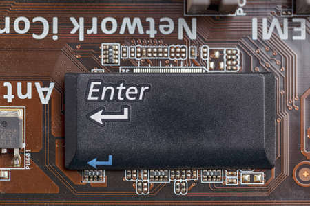 Circuit board close-up on top of the chip on the motherboard enter buttonの写真素材