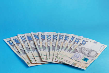a lot of banknotes money 500 hryvnia lie on blue background