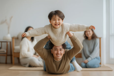Smiling dad lifting kid on back while family watches ideal for parenting blogs insurance ads and family lifestyle campaignsの素材