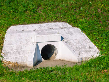 Concrete pipe for storm water drainage next to the road. The pipe is made of reinforced concrete for wastewater drainage.の写真素材