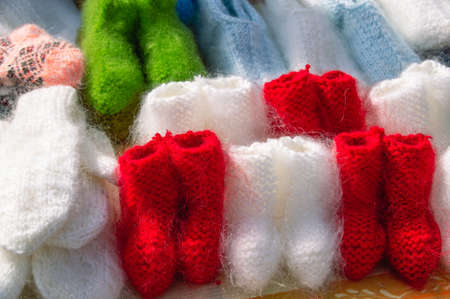 Red and white knitted wool socks for children. The market of knitted things. street market.の写真素材