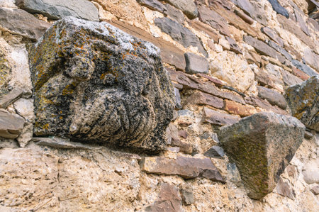 Background of the masonry of an ancient temple. Place of religious ceremonies. An ancient stone wall with images that have undergone devastating erosion.の写真素材