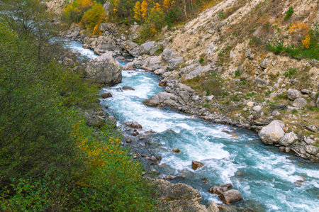 A huge gray boulder lies in a mountain river. A mountain river with clear and transparent water. Landscape with a view of gray stones in a mountain river.の写真素材