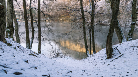 Karst deep-water lake high in the mountains. Lake in winter with a view of snow-covered trees. Trees in the snow growing on the mountainside. Clean water in a non-freezing mountain lake. Fog on the lake in the mountains.の写真素材